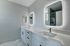 Elegant bathroom with dual sinks, quartz countertops, and backlit mirrors, perfect for a luxurious start to your day.
