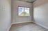 Bright room with modern gray walls, large window, and stylish wood flooring.