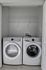 Modern laundry closet featuring a sleek washer and dryer with ample overhead shelving.