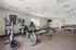 Modern fitness center with state-of-the-art exercise equipment, free weights, and large windows for natural light.