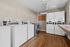 Modern and efficient laundry room featuring multiple washing machines and dryers with sleek white design on wooden flooring, perfect for convenient washing needs.