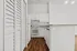 Contemporary galley kitchen with sleek white cabinets, modern appliances, and warm wood flooring for a cozy ambiance.
