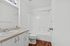 Pristine bathroom featuring a sleek vanity, polished countertop, and bright shower area.
