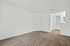 Spacious bedroom with plush carpet, white walls, closet, and bathroom access, perfect for comfort and style.