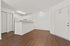 Charming open-concept apartment with sleek wood flooring, modern white cabinetry, and ample natural light.