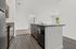 Chic open-concept kitchen with modern appliances, sleek countertops, and a view into a sunlit living room.