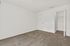 Bright and spacious bedroom featuring fresh white walls, plush carpet flooring, and a convenient built-in closet.