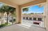 Charming balcony view overlooking lush palm trees and tiled rooftops, perfect for relaxation and enjoyment.
