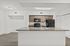 Modern kitchen with sleek granite countertops, dark appliances, and light wood cabinets, offering a blend of style and functionality.