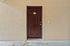 Inviting brown door on a textured beige wall offers a warm welcome to your future home.