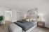 Inviting bedroom with elegant decor, cozy bed, and stylish artwork, complemented by a modern ensuite bathroom.