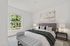 Luxurious bedroom with a plush king-sized bed, elegant decor, and a window view of lush greenery, creating a serene retreat.
