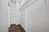 Spacious walk-in closet with sleek wire shelving and plush carpet, perfect for organized storage.