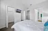 Bright and spacious bedroom featuring a cozy bed with elegant bedding, large walk-in closet, and a modern flat-screen TV.