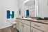 Elegant bathroom with modern granite countertop, stylish wood cabinets, and vibrant teal accents creating a refreshing atmosphere.
