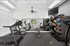 Modern fitness center with state-of-the-art equipment, including treadmills, ellipticals, and colorful medicine balls, set in a bright and inviting space.