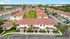 Charming residential complex with red-roofed townhouses and lush green spaces, offering modern suburban living.