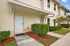 Inviting townhouse entrance with manicured hedges and a pristine walkway.