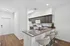 Contemporary kitchen with sleek granite countertops, modern appliances, and an inviting breakfast bar with stylish stools.