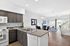 Bright open-concept kitchen and living space with modern finishes, featuring sleek granite countertops and stylish dining area with a view of the lush outdoor space.