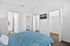 Bright bedroom with inviting blue paisley bedding, spacious walk-in closet, and a modern en-suite bathroom.