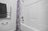 Modern bathroom with a pristine white bathtub, elegant paisley shower curtain, and soft luxury towels.