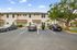 Welcoming townhouse with attractive red roof, convenient parking, and lush greenery in a serene neighborhood.