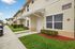 Charming townhouse exterior with well-maintained landscaping and a welcoming front entrance in a quaint neighborhood setting.