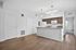 Inviting apartment interior featuring a modern kitchen with white appliances and sleek cabinetry, leading to a bright bedroom with natural light.