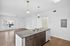Bright, open-concept apartment with elegant kitchen island, hardwood floors, and natural light streaming through large windows.