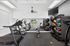 Modern fitness center with state-of-the-art treadmills, elliptical machines, and a variety of exercise balls and weights, featuring large mirrors and ample natural light.