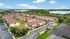 Charming apartment complex with red-roofed buildings, set in lush greenery and ample parking. Ideal for serene living.