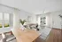 Elegant living room with modern furniture, wooden floors, and abundant natural light from large windows, perfect for relaxation.