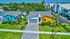 Aerial view of modern single-family homes with colorful exteriors, lush landscaped gardens, and a serene suburban ambiance.