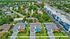 Vibrant aerial view showcasing colorful  single-family modern homes with lush green lawns in a peaceful neighborhood setting.