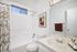 Contemporary bathroom featuring a sleek countertop, stylish faucet, and vibrant decorative accents.