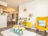 Bright and inviting open-plan living area featuring a vibrant yellow chair, modern decor, and a stylish dining space in the background.