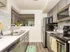 Sleek and modern kitchen with stainless steel appliances, chic hexagonal backsplash, and elegant wood flooring.