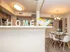 Inviting dining area with modern decor, elegant chandelier, and cozy 'HOME' accent in a stylish open-plan apartment.