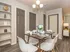 Elegant dining area with a chic table set for four, stylish open shelving, and warm lighting creating a cozy ambiance in a modern apartment.