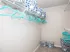 Spacious walk-in closet featuring organized shelving, stylish storage boxes, and vibrant teal hangers, ideal for maximizing space.