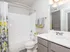 Bright and modern bathroom featuring a sleek vanity, elegant lighting, and a stylish shower curtain with floral accents.