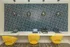 Chic workspace with vibrant yellow chairs, sleek marble desk, and modern geometric wall design.