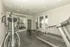 Bright and modern apartment fitness center featuring state-of-the-art treadmills, an elliptical, free weights, and medicine balls.