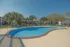 Inviting community pool surrounded by lush palm trees and modern lounge chairs, perfect for relaxation and enjoyment.