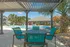 Charming outdoor lounge area with stylish poolside seating and lush palm tree views, perfect for relaxation.