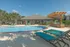 Charming outdoor pool area with lush palm trees, modern sun loungers, and stylish pergola, perfect for relaxation and leisure.