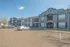 Charming two-story apartment complex with modern architecture, ample parking, and beautifully maintained greenery.