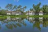 Charming apartment complex with lakefront view, lush greenery, and serene surroundings.