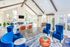 Inviting lounge area with elegant navy and orange seating, high ceilings, and abundant natural light, ideal for relaxation and socializing.